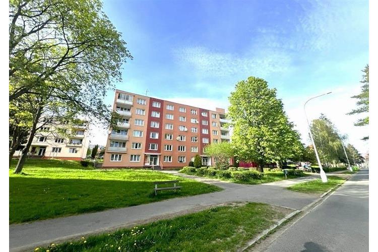 Šestipatrový bytový dům s barevnou fasádou, umístěný v klidné zelené čtvrti, nabízí prostorné byty s výhledem do přírody.