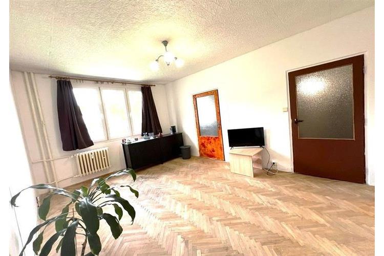 Světlý obývací pokoj s parketovou podlahou, velká okna zajišťují dostatek denního světla, klasický styl interiéru