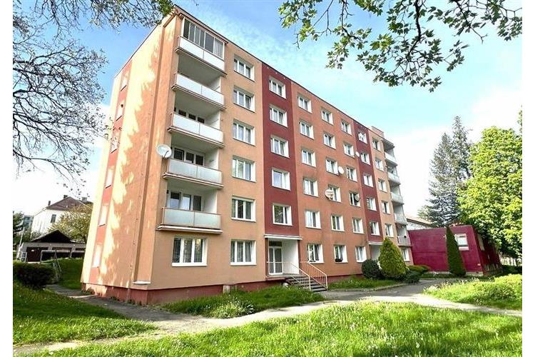 Čtyřpodlažní bytový dům s balkony, obklopený trávníkem a zelení, v dobrém stavu, nachází se v klidné lokalitě.