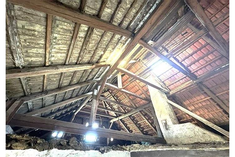 Podkrovní prostor s dřevěnými trámy, původní střešní konstrukce a přirozené osvětlení. Ideální pro rekonstrukci nebo úpravu obytného prostoru.