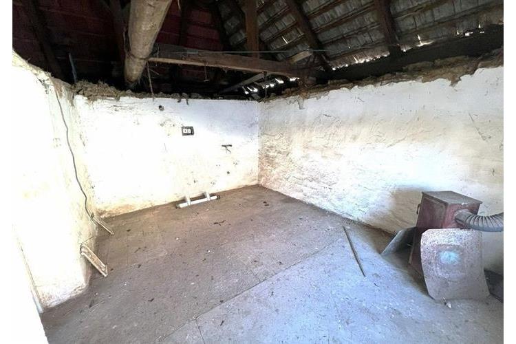 Starší podkrovní prostor s dřevěným stropem a omítanými stěnami, vhodný k rekonstrukci, nabízí využití pro skladování nebo jako dílna.