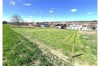 Stavební pozemek s rovným terénem a výhledem na město, ideální pro rodinný dům. Klidná lokalita s dostupností městské infrastruktury.