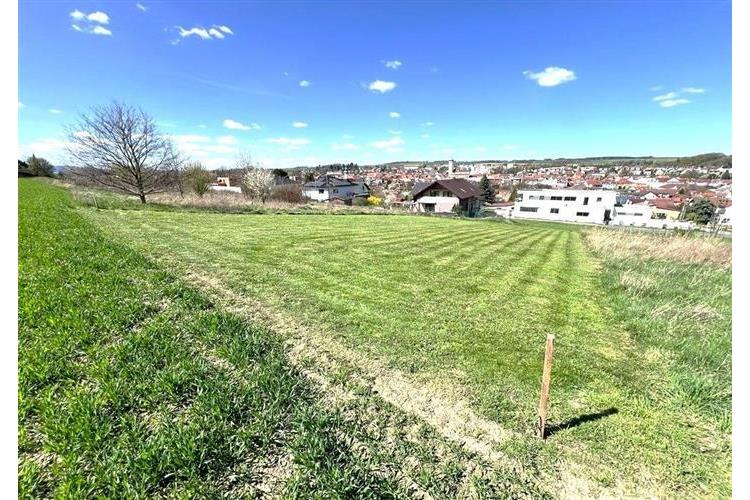 Stavební pozemek s rovným terénem a výhledem na město, ideální pro rodinný dům. Klidná lokalita s dostupností městské infrastruktury.