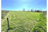 Stavební pozemek s rovinným terénem a upraveným trávníkem, ideální pro výstavbu. Klidná lokalita obklopená zelení, skvělá investiční příležitost.