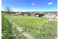 Stavební pozemek s rovinatým terénem, ideální pro výstavbu rodinného domu, v klidné lokalitě s výhledem na město, dostupné inženýrské sítě