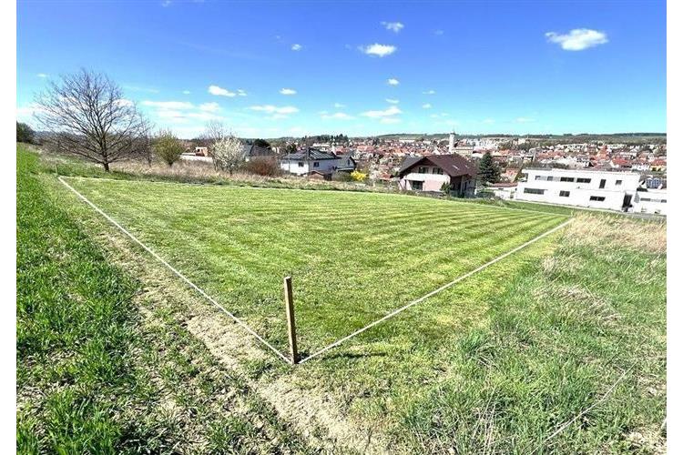 Stavební pozemek s rovinatým terénem, ideální pro výstavbu rodinného domu, v klidné lokalitě s výhledem na město, dostupné inženýrské sítě