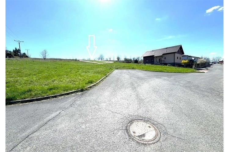 Stavební pozemek na okraji obce se zpevněnou přístupovou cestou, vhodný pro rodinný dům, nabízí mírný svah a klidnou lokalitu v přírodě.