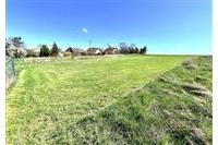 Plochý stavební pozemek s udržovaným trávníkem, ideální pro výstavbu. Klidná lokalita, obklopena přírodou a blízkostí obytných domů.