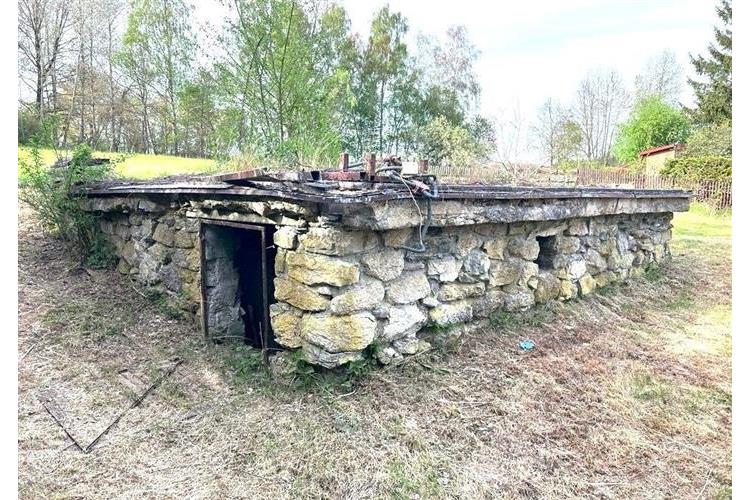 Kamenný sklep nabízí rustikální atmosféru s masivními stěnami, ideální pro rekonstrukci. Přírodní materiál a potenciál pro úložný prostor.